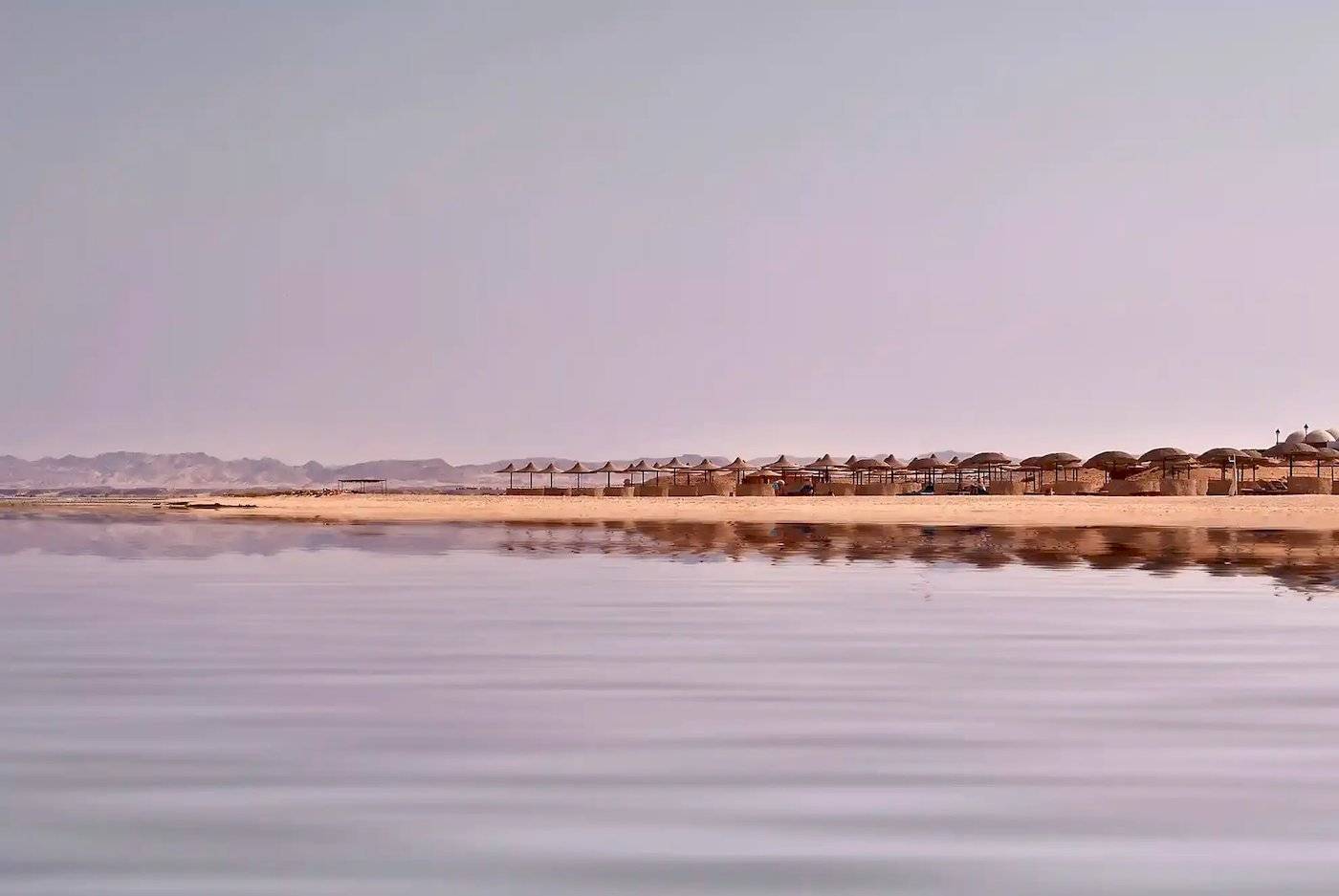 Strand des Gorgonia Beach Resorts mit vielen Sonnenschirmen am Horizont