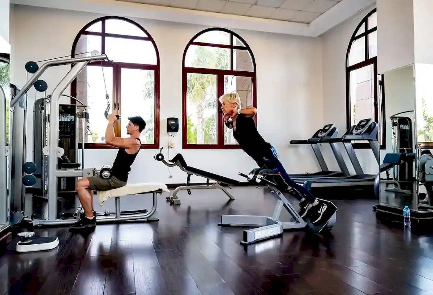 Fitness-Training im Gorgonia Beach Resort-Hotel-Gym mit zwei Personen, die verschiedene Geräte nutzen.