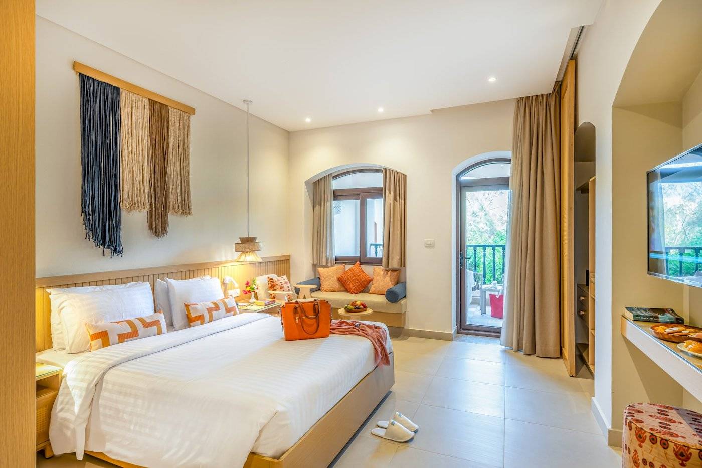 Drei-Ecken-Rihana-Resort-Zimmer mit großem Bett, Balkon und modernem Interieur.