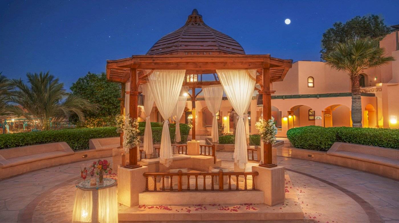 Drei-Ecken-Rihana-Resort-Garten-Pavillon, der nachts mit Blumen und Lichtern dekoriert ist.