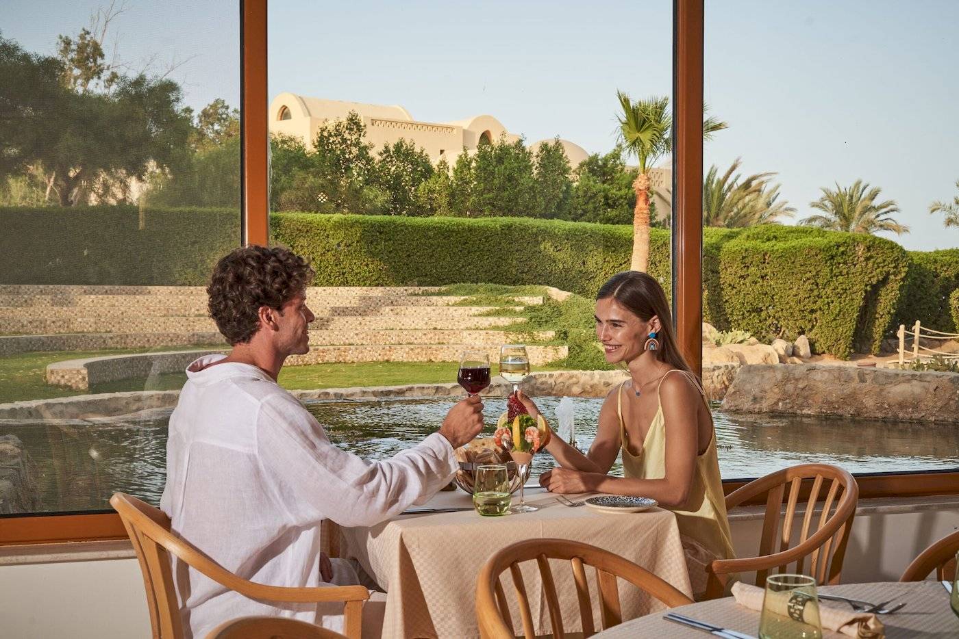 Paar genießt Mahlzeit mit Blick auf Hotelpool im Three Corners Rihana Resort