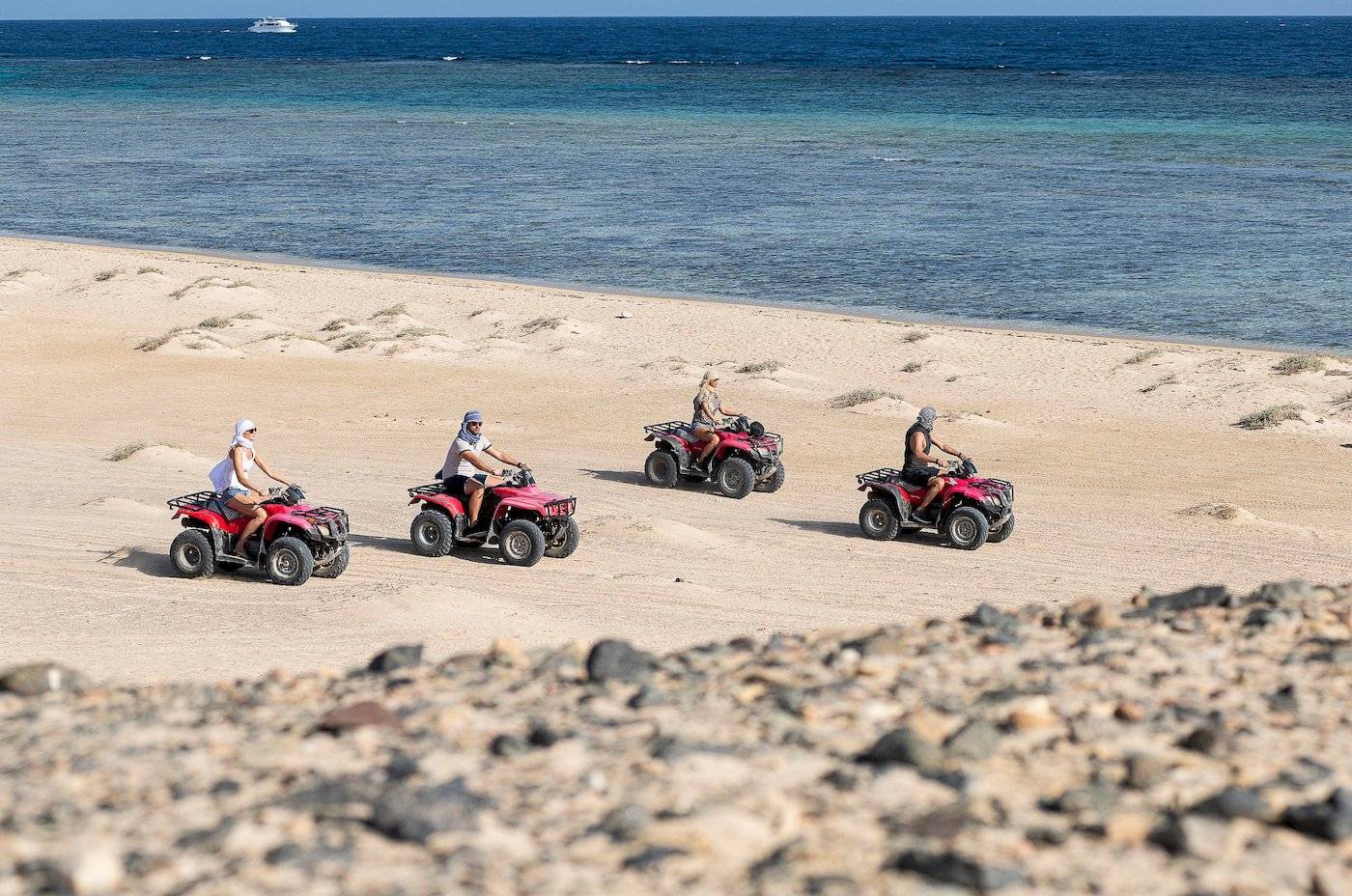 Vier Personen auf Quads am Strand des Three Corners Fayrouz Plaza Beach Resort.