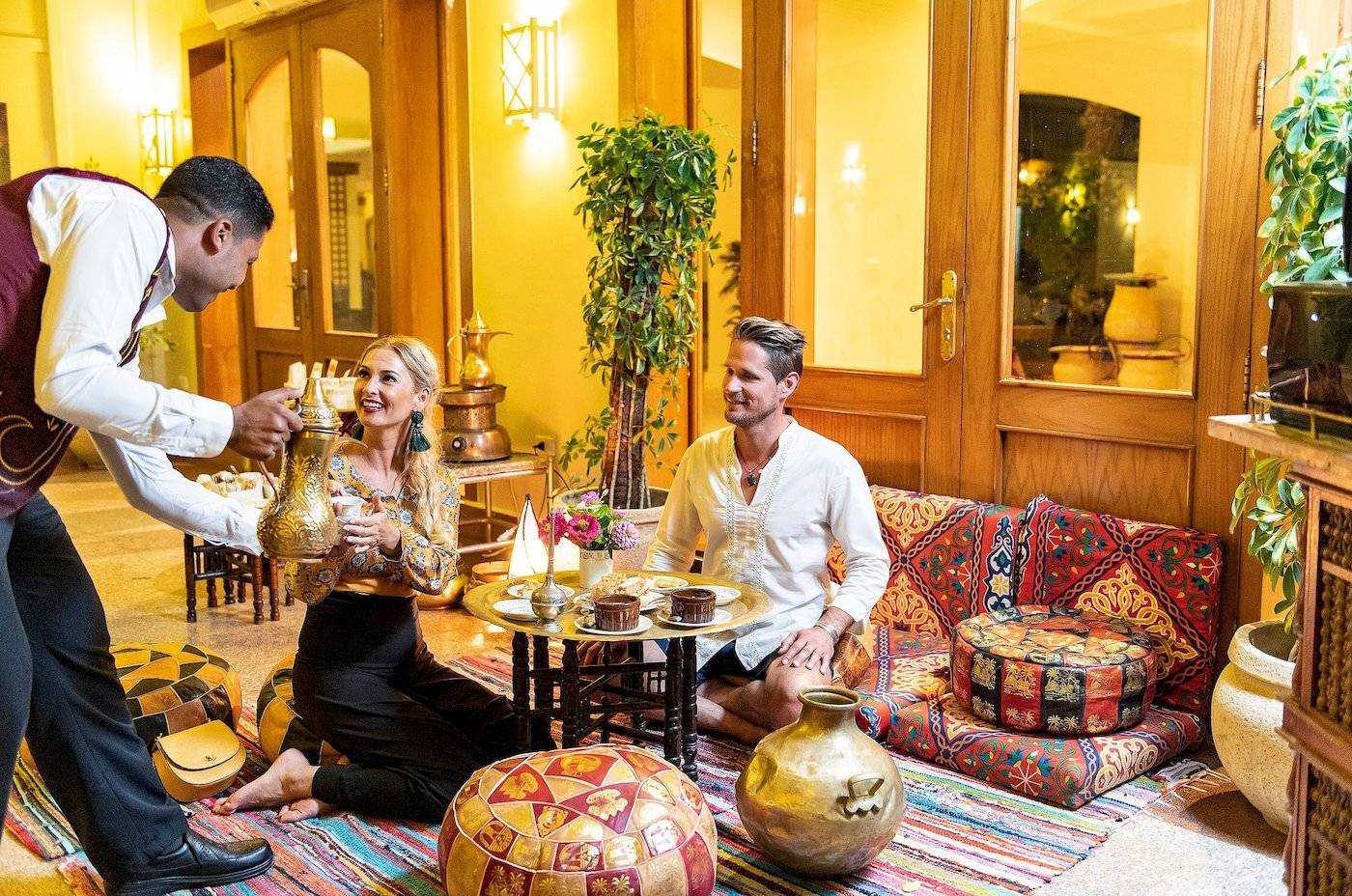 Ein Hotelmitarbeiter serviert ein Paar im Drei Ecken Fayrouz Plaza Strand Resort.