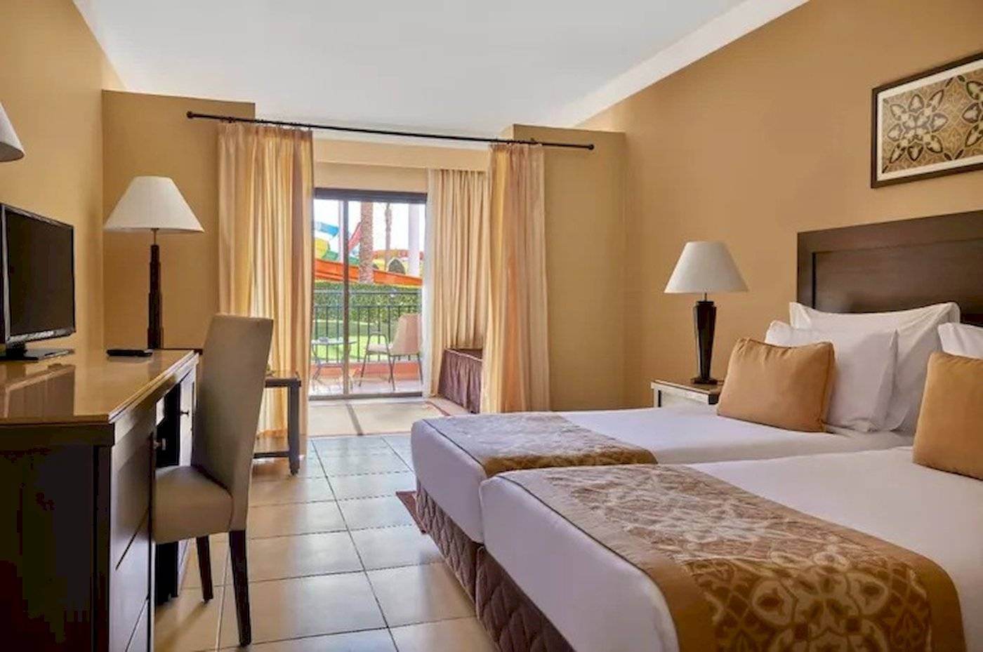 Hotelzimmer im JAZ Neo Dar El Madina mit zwei Betten, Schreibtisch und Balkon