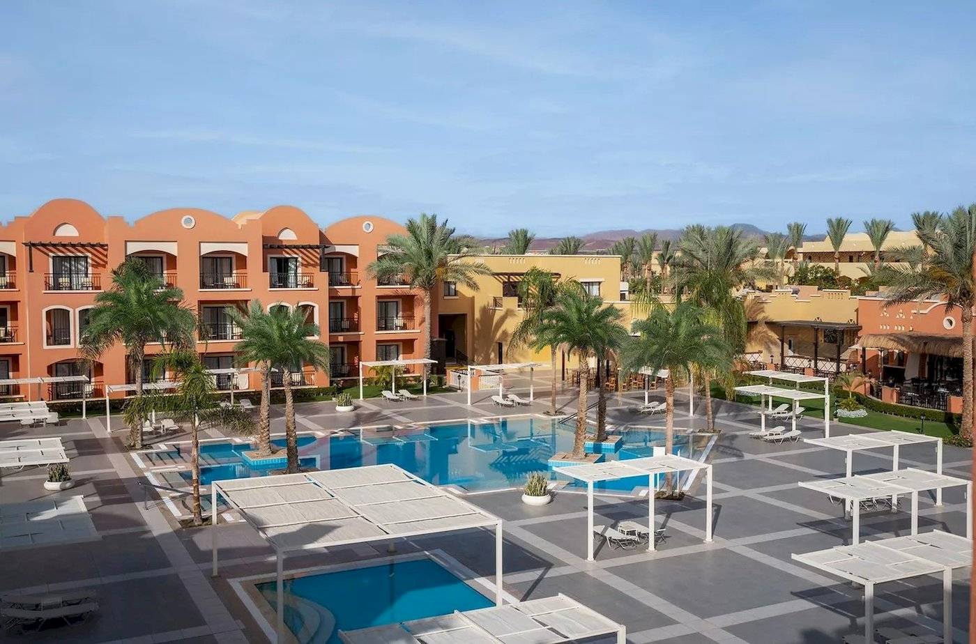 Außenansicht des Jaz Neo Dar El Madina Hotels mit Swimmingpool und Sonnenliegen