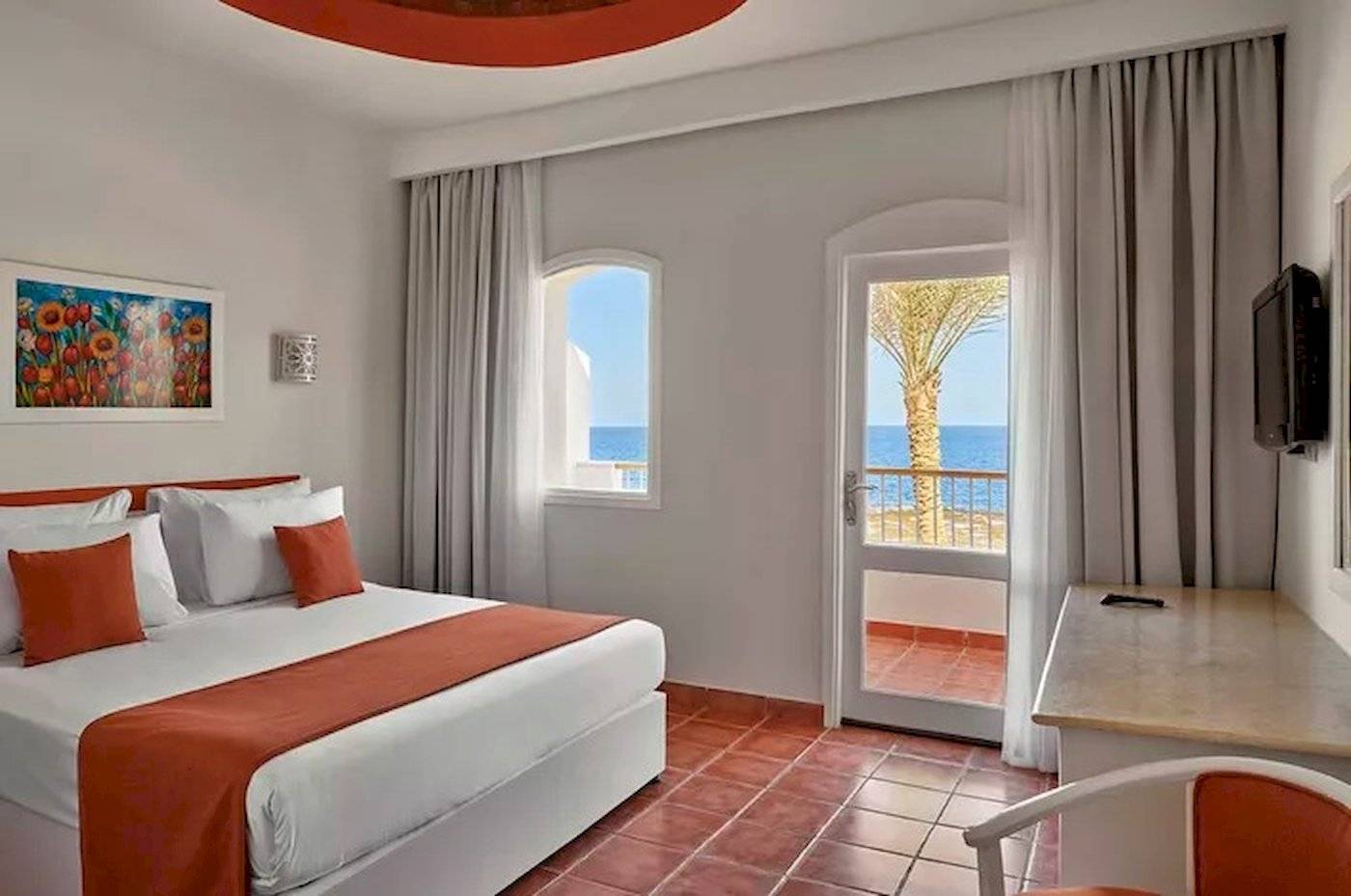 Hotelzimmer mit Bett und Balkon mit Meerblick im JAZ Neo Reef Marsa