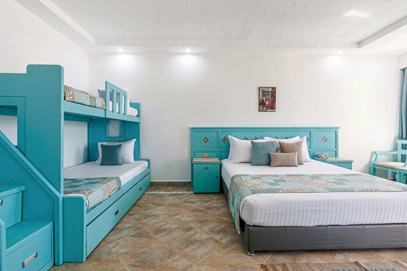 Zwei-Bettzimmer im Sunrise Royal Makadi Resort mit blauen Möbeln und einer Treppe.