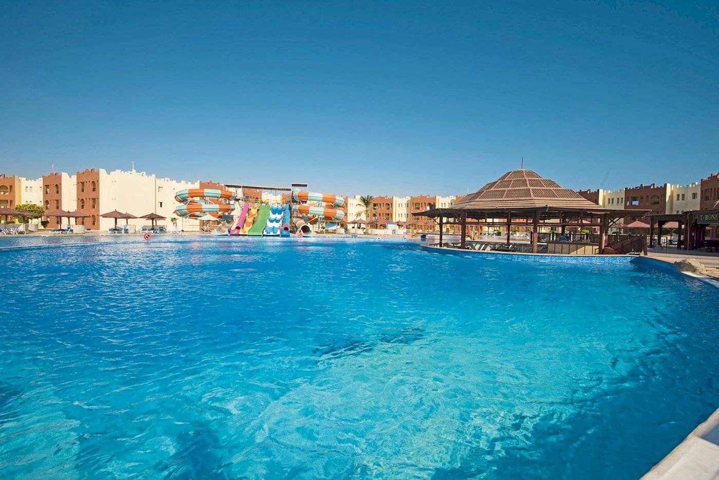 Außenpool des Sunrise Royal Makadi Resorts mit Wasserrutschen und Cabanas.