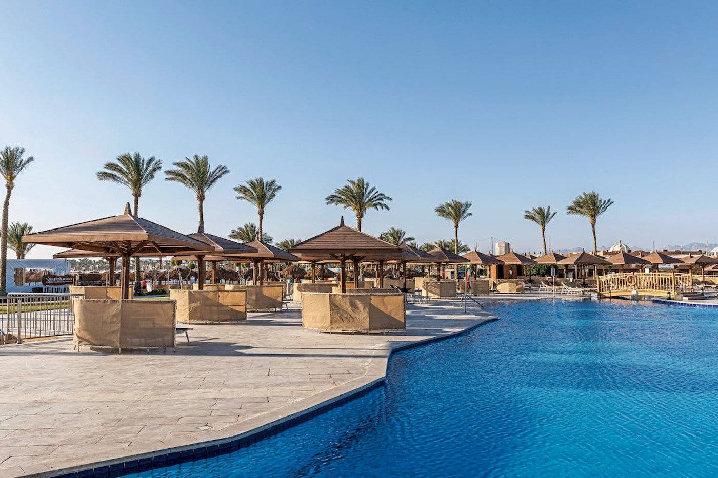 Poolbereich des Sunrise Royal Makadi Resorts mit Palmen und Sonnenschirmen