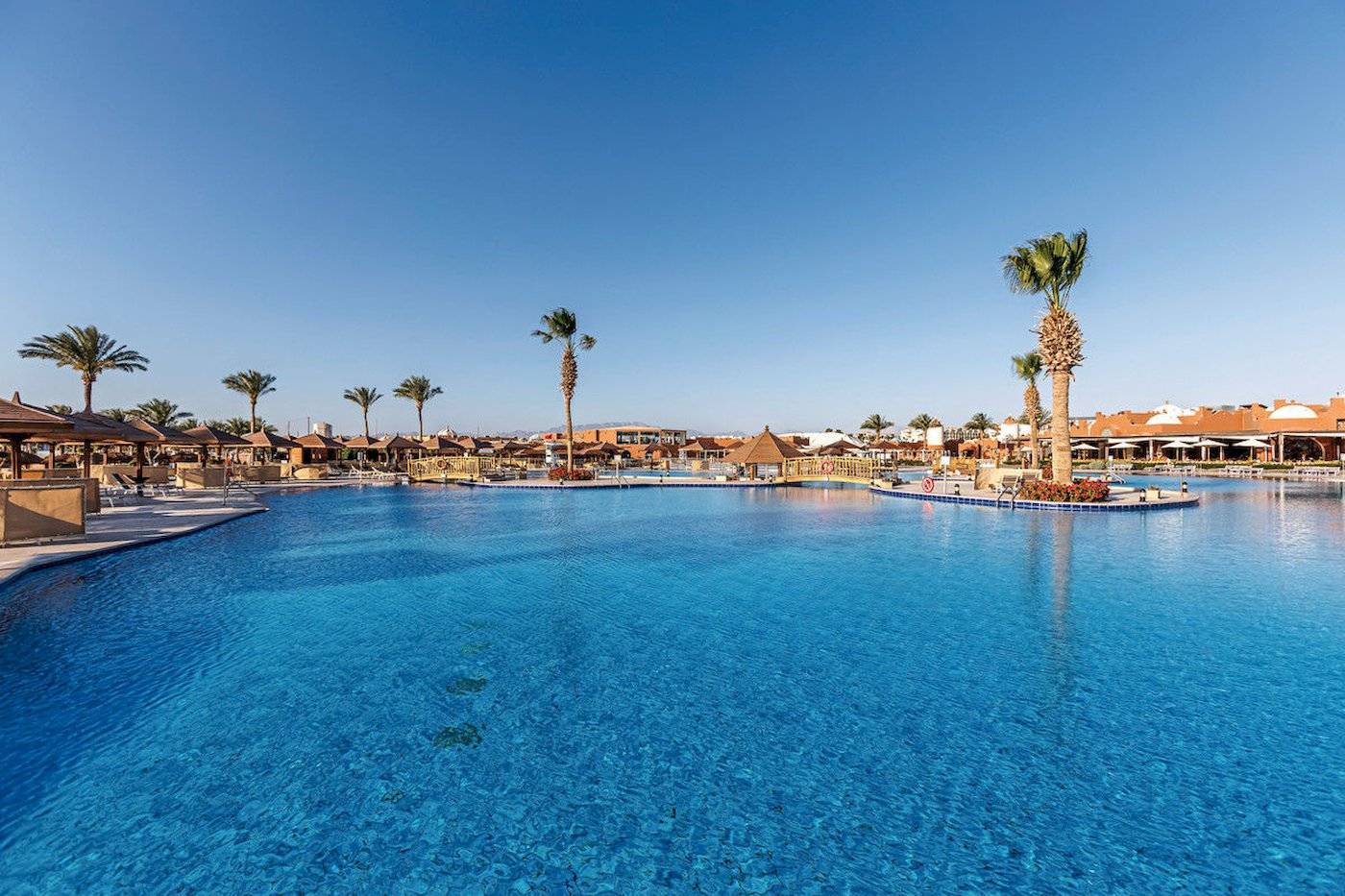 Außenpool im Sunrise Royal Makadi Resort mit Palmen und Sonnenschirmen