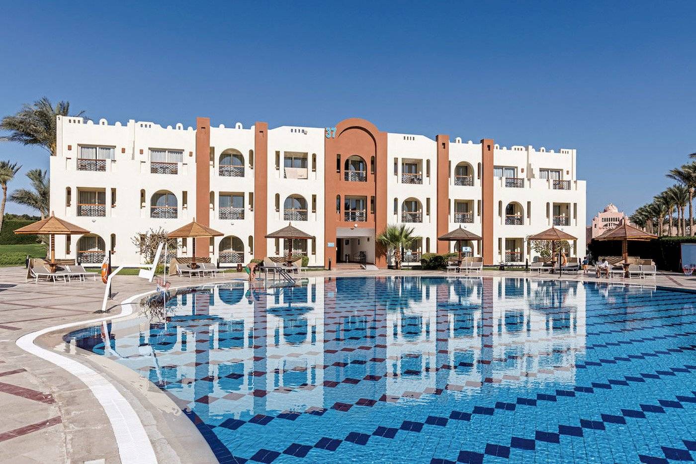 Außenbereich des Sunrise Royal Makadi Resort mit Swimmingpool und Hotelgebäude