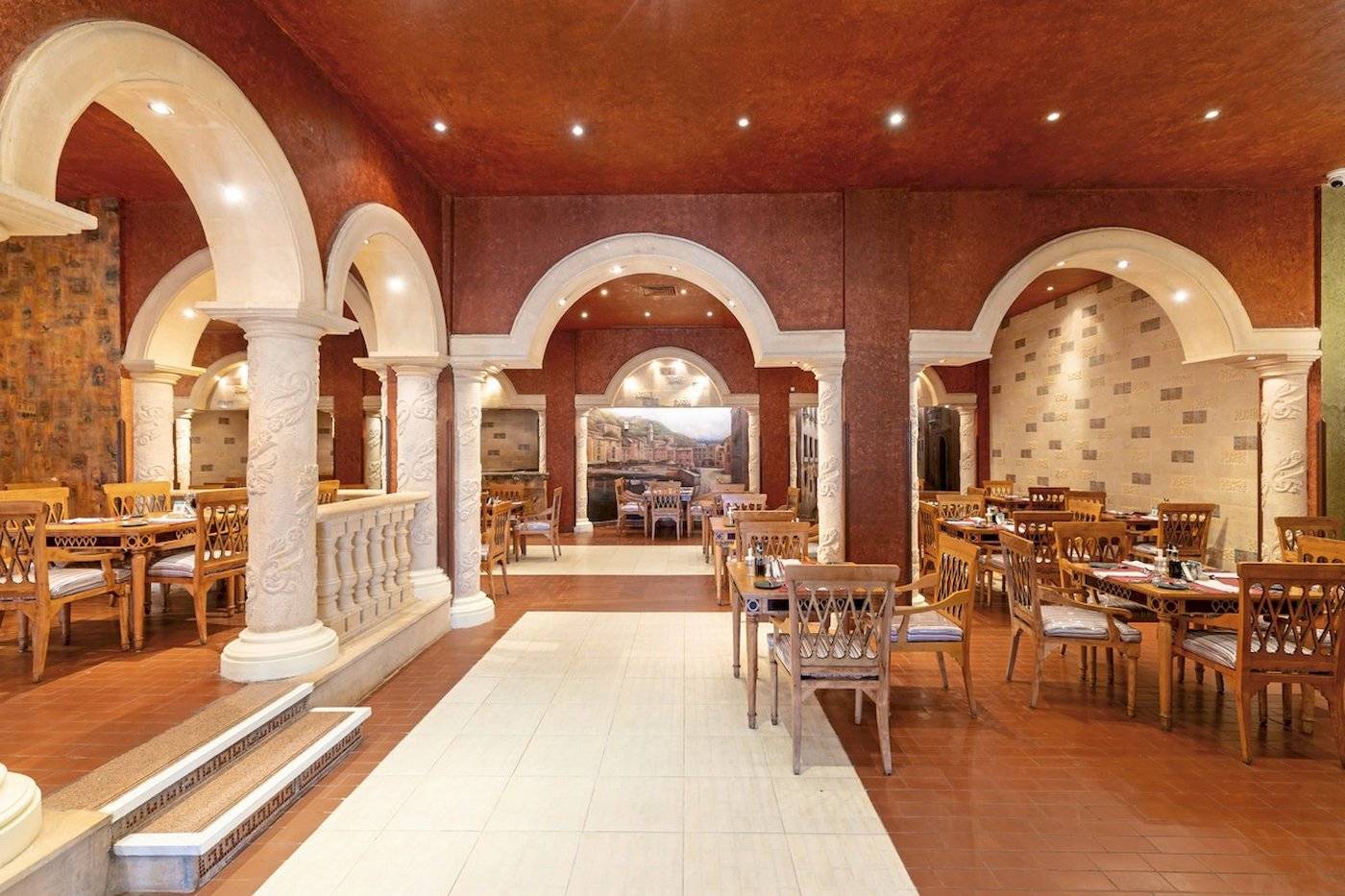 Restaurant im Sunrise Royal Makadi Resort mit Holztischen und Stühlen.