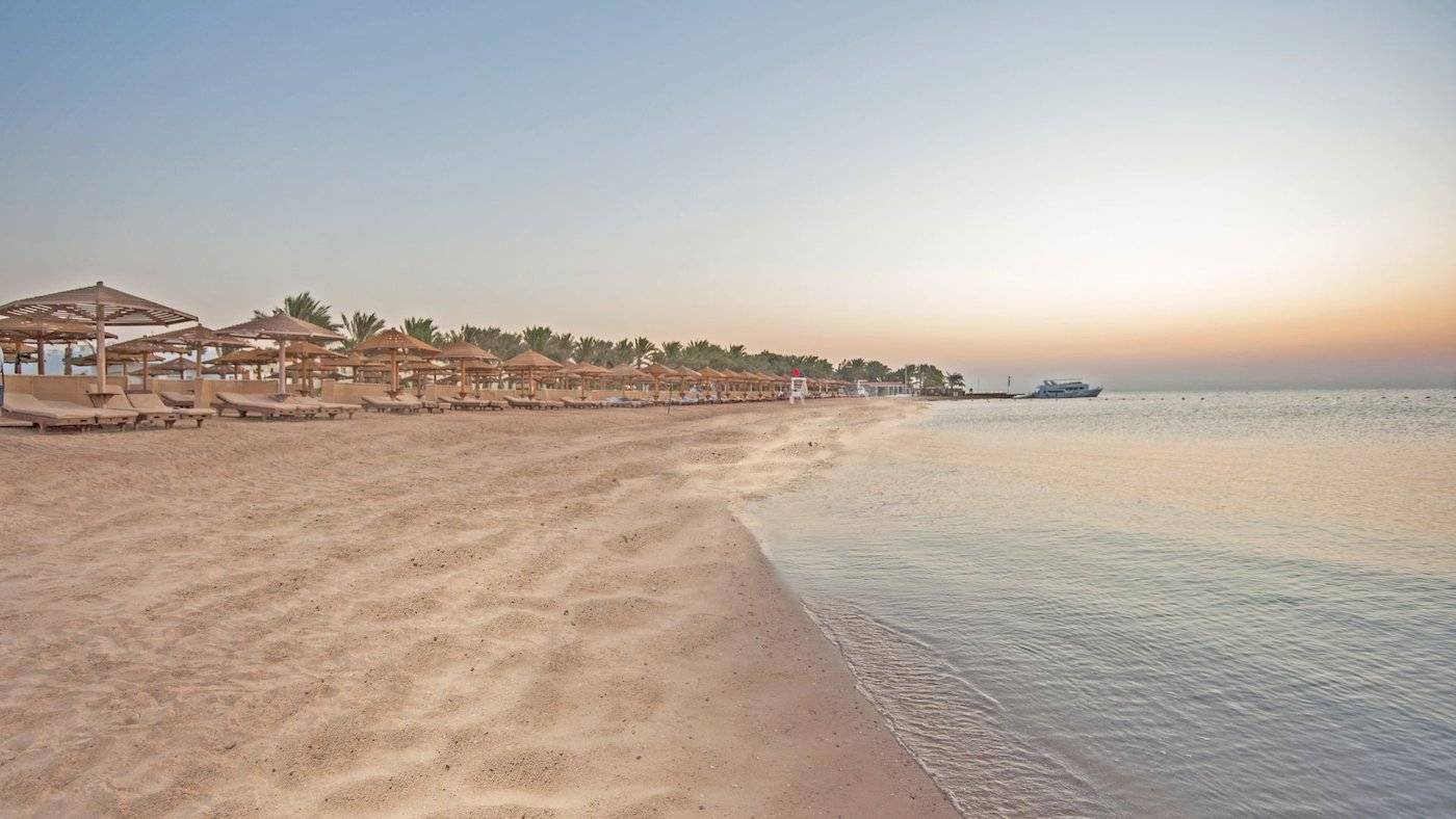 Strand des SUNRISE Royal Makadi Resorts mit Sonnenschirmen und Liegen