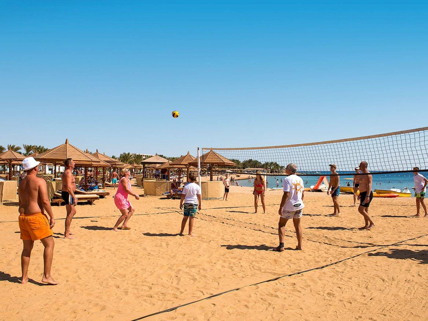 Beachvolleyball-Spiel am Sunrise Royal Makadi Resort mit Teilnehmern und einem Ball in der Luft.