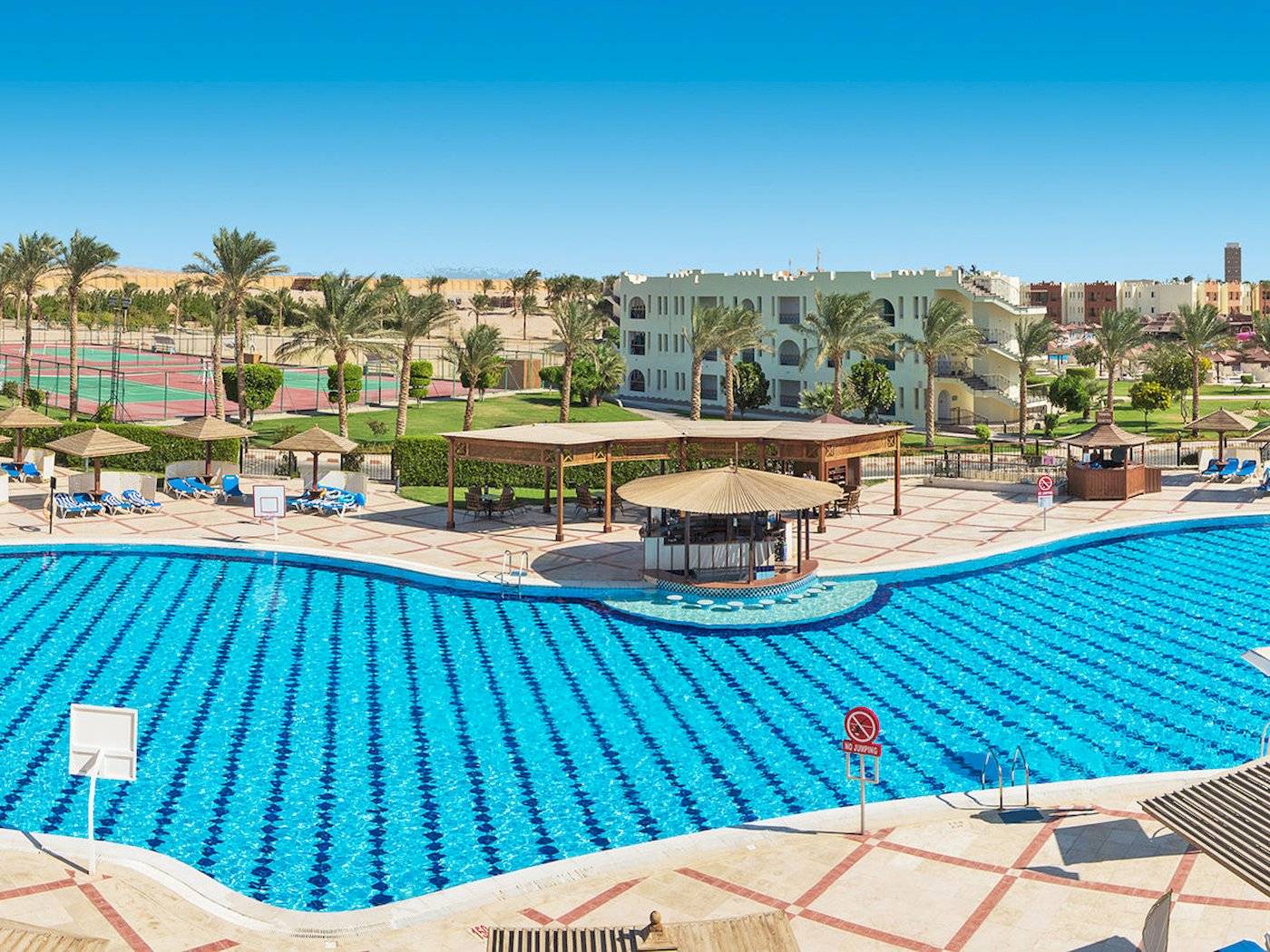 Luftaufnahme des Swimmingpools des Sunrise Royal Makadi Resort mit Liegen und Sonnenschirmen.