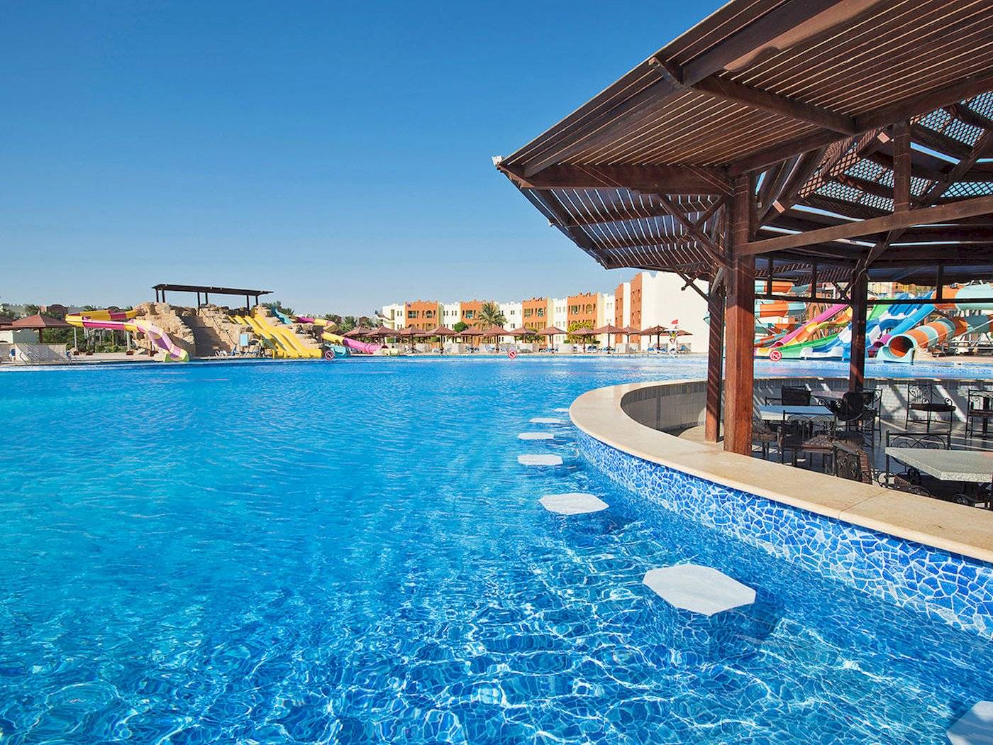 Außenpool des Sunrise Royal Makadi Resorts mit Wasserrutschen im Hintergrund.
