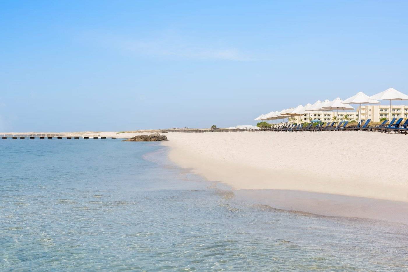 Wyndham Garden Salalah Mirbat Hotel Strand mit Sonnenschirmen und Liegen