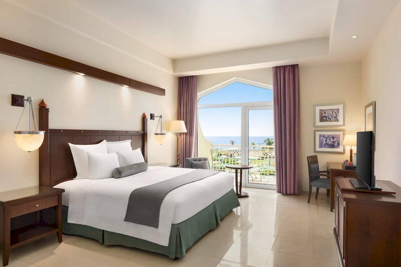 Wyndham Garden Salalah Mirbat Hotel Zimmer mit Kingsize-Bett und Meerblick.
