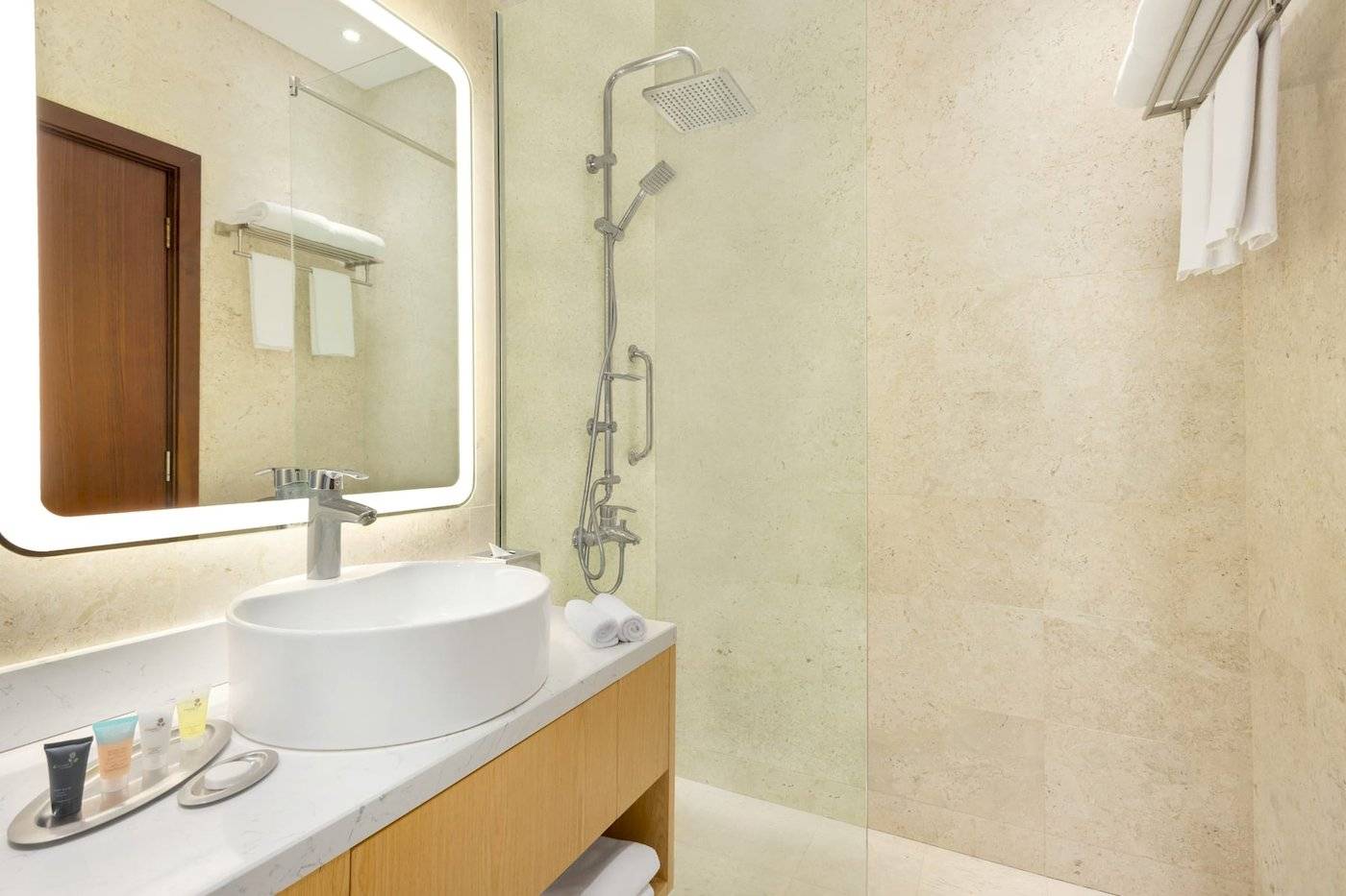 Badezimmer im Wyndham Garden Salalah Mirbat Hotel mit Waschbecken, Spiegel und Dusche
