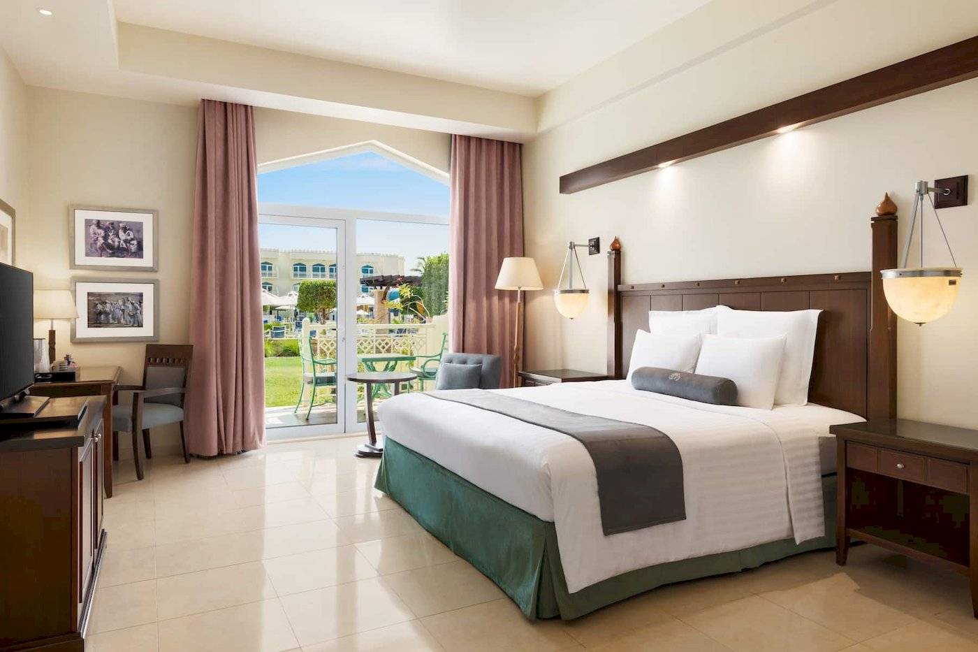 Wyndham Garden Salalah Mirbat Hotelzimmer mit Bett, Schreibtisch, Fernseher und Balkon.