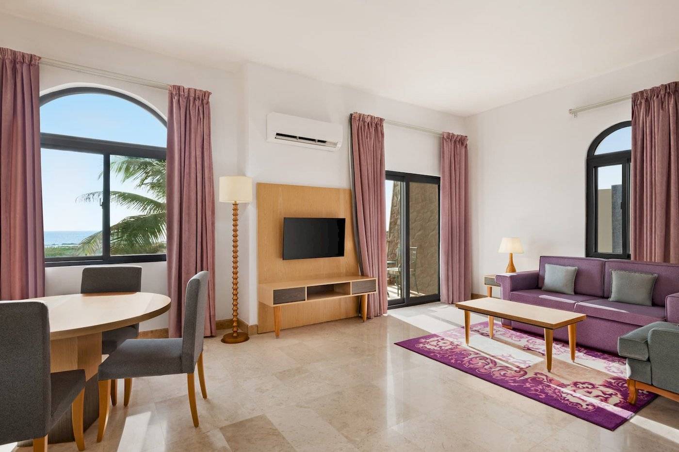 Wohnzimmer im Wyndham Garden Salalah Mirbat Hotel mit Möbeln, Fernseher und Meerblick