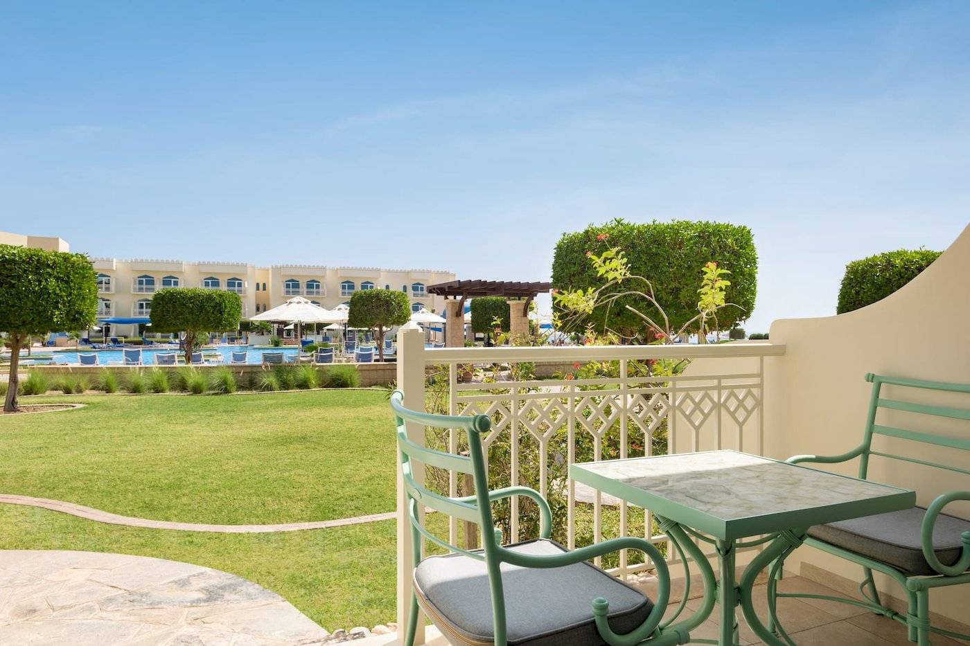 Blick vom Balkon des Wyndham Garden Salalah Mirbat Hotels auf den Swimmingpool und die Gärten.