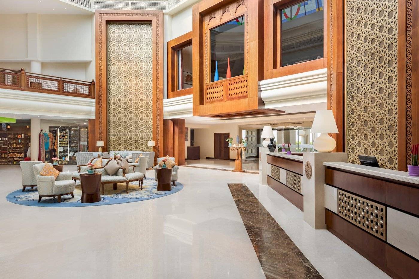 Empfangsbereich des Wyndham Garden Salalah Mirbat Hotels mit Loungemöbeln und Holzdekoration.