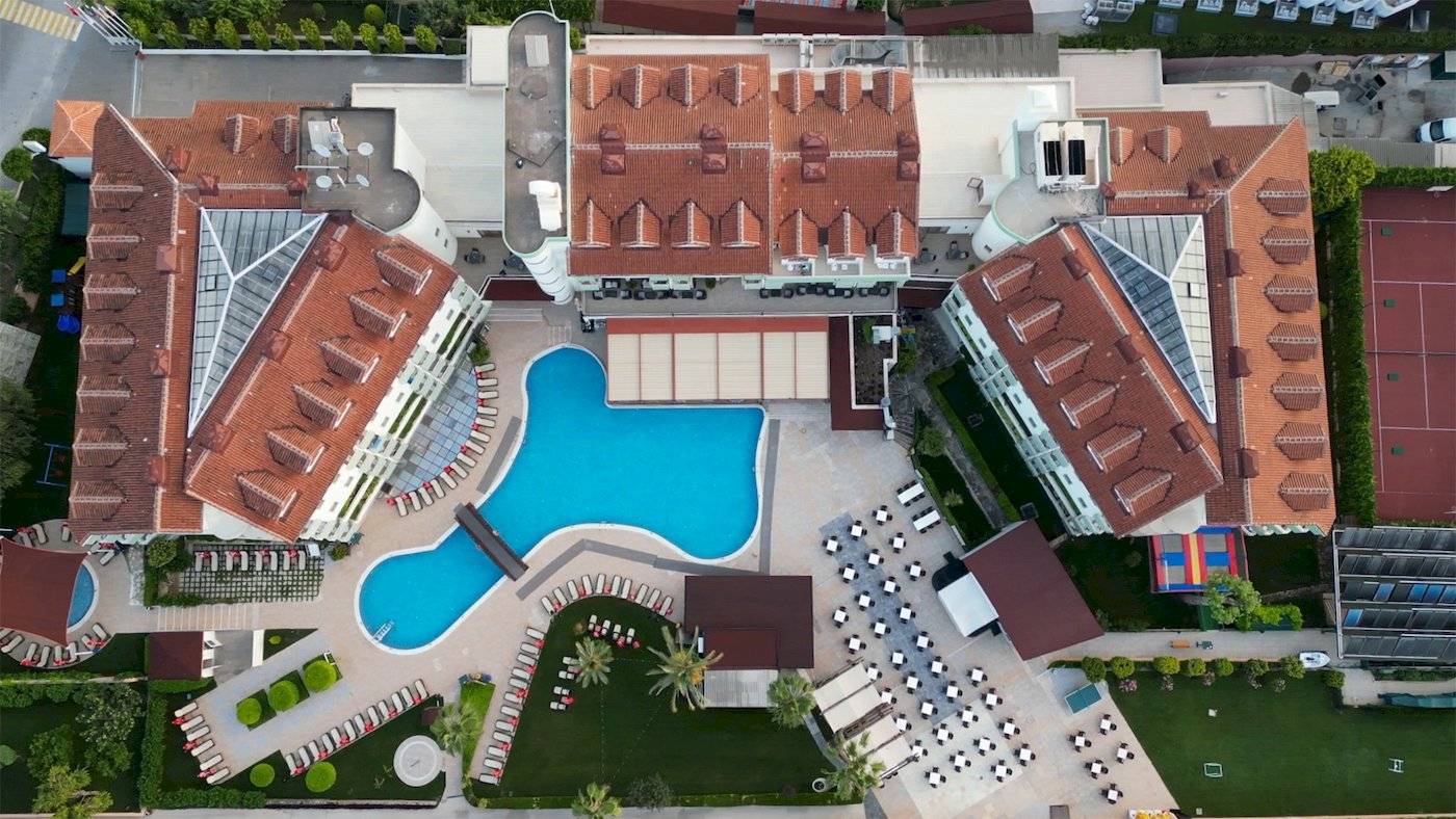 Außenansicht des Monachus Hotel & Spa mit Swimmingpool und Liegebereich.