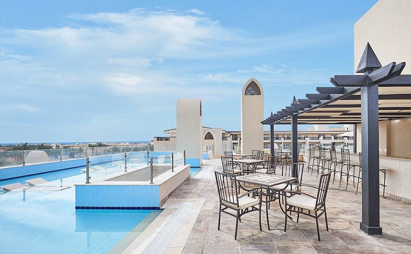 Außenterrasse mit Swimmingpool und Tischen des Steigenberger Aqua Magic Hotels.