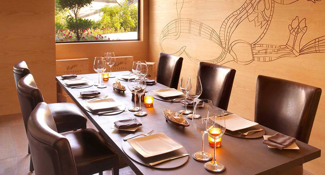 Ein elegantes Esszimmer im Anantara The Palm Dubai Resort mit gedecktem Tisch und Kerzen.