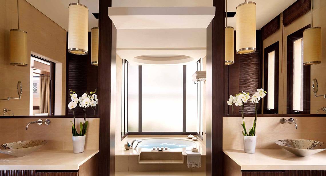 Luxuriöses Badezimmer im Anantara The Palm Dubai Resort mit einem Jacuzzi und zwei Waschbecken.