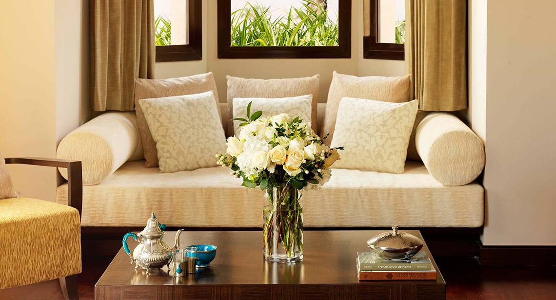 Wohnzimmer im Anantara The Palm Dubai Resort mit Couch und Blumenvase auf dem Tisch