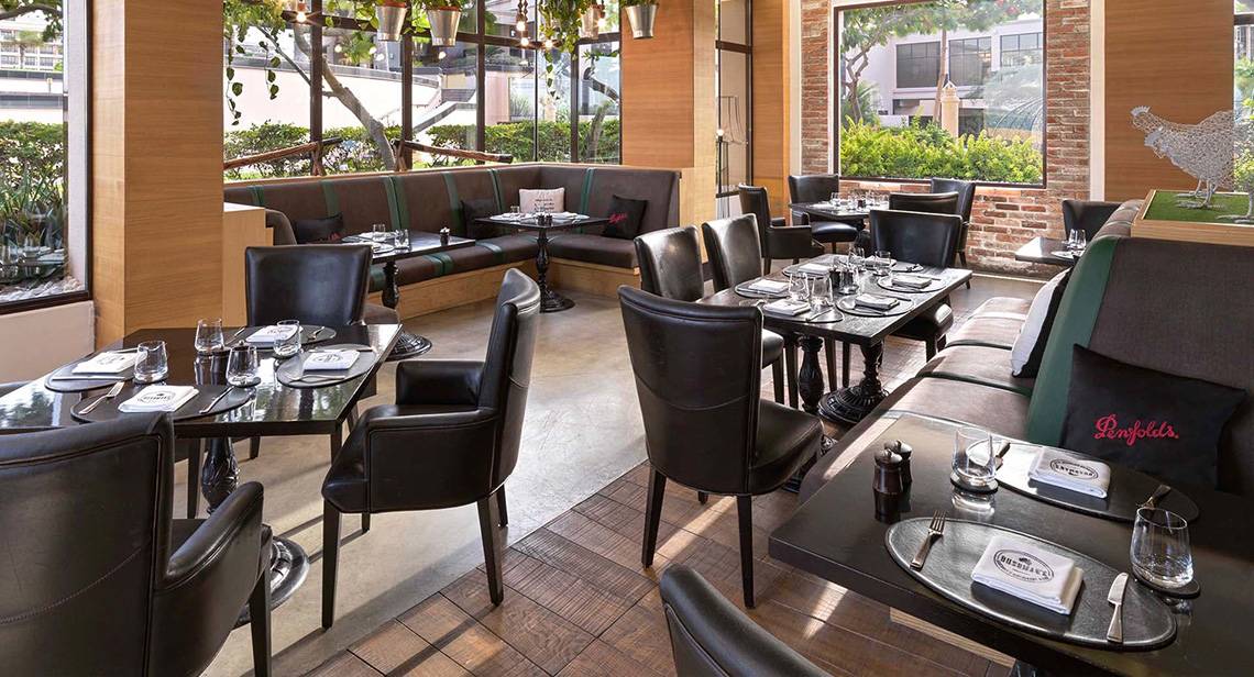 Innenansicht des Restaurants im Anantara The Palm Dubai Resort mit schwarzen Möbeln und Tischdekoration.