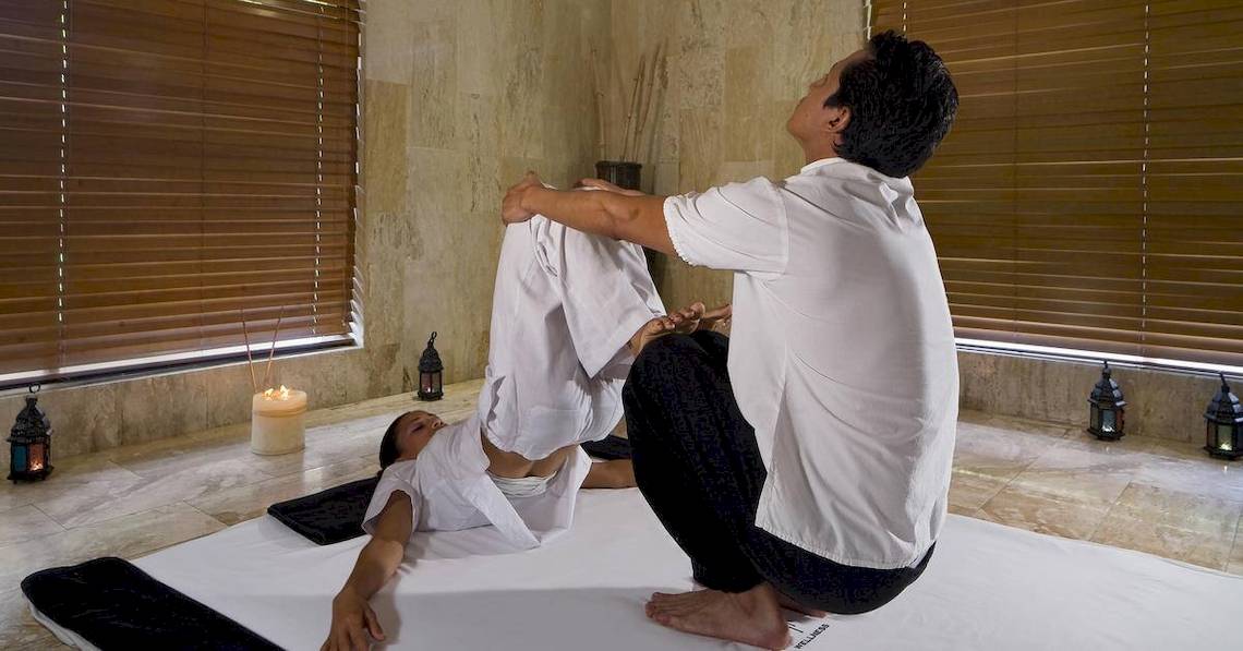 Yoga-Sitzung im Melia Caribe Beach Resort mit Kerzen und Holzfensterläden im Hintergrund.
