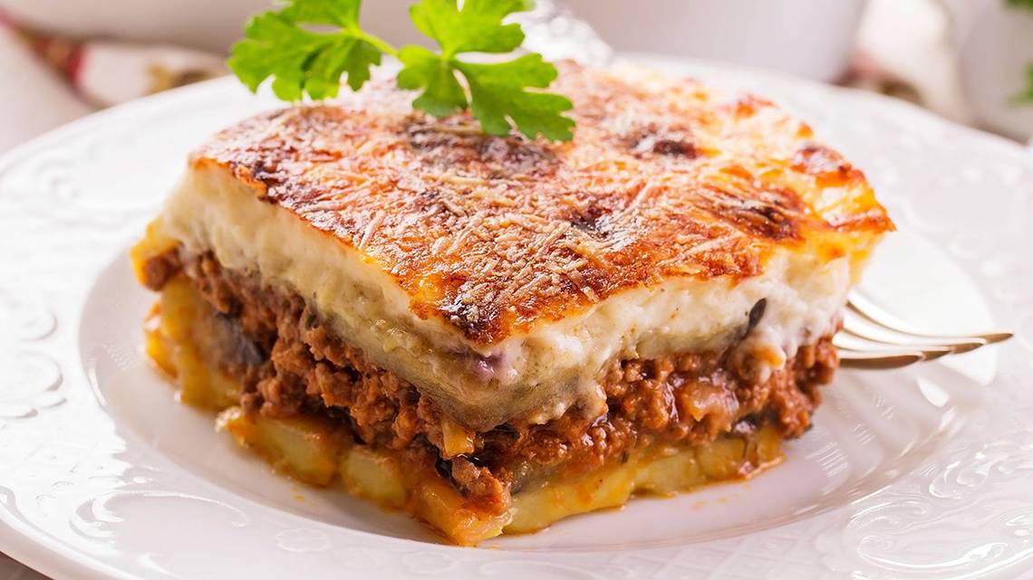 Griechisches Lasagne auf einem weißen Teller mit einer Gabel