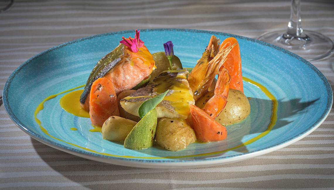 Fischgericht im Atrium Palace Thalasso Spa Resort & Villas mit Lachs, Garnelen, Kartoffeln und Karotten.