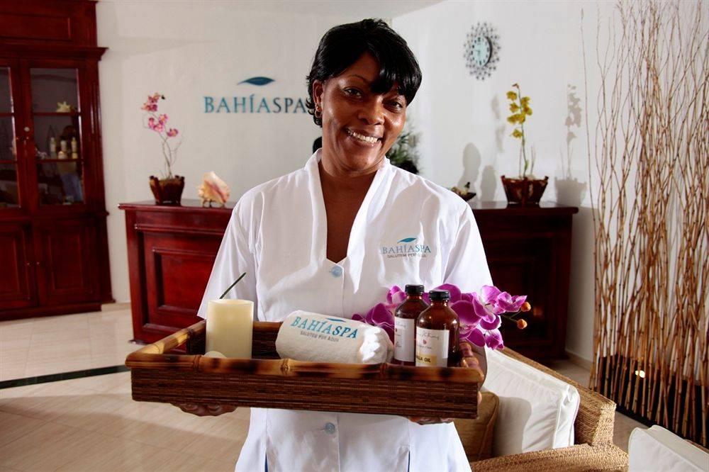 Frau im Bahia Spa des Grand Jamaica Hotels, die ein Tablett mit Spa-Produkten hält.