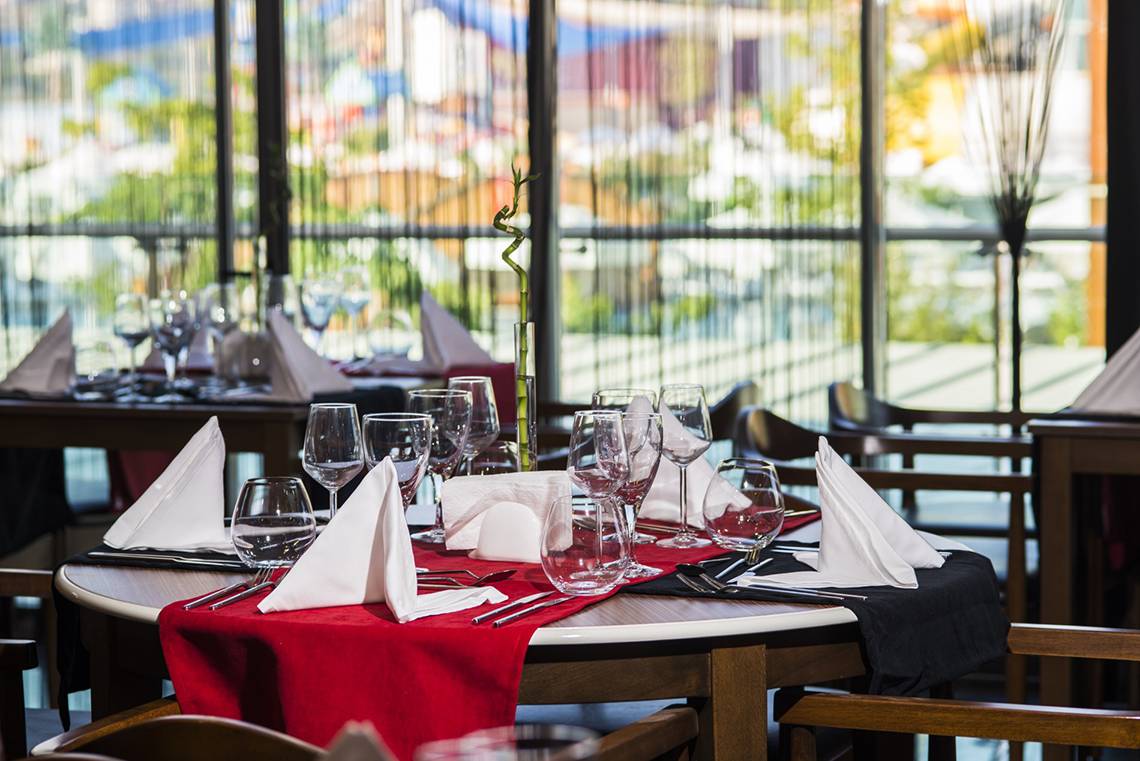 Tisch im Dream World Aqua Hotel Restaurant mit roter Tischdecke und serviertem Besteck.