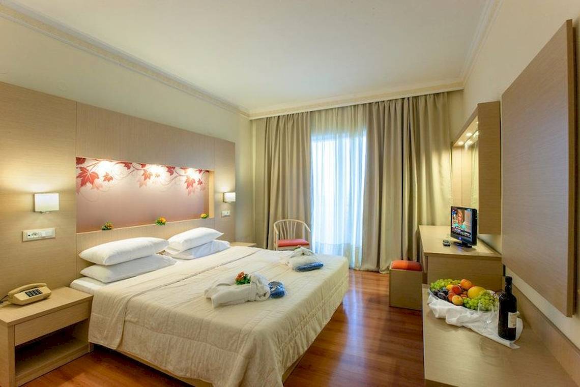 Marianna Palace Hotelzimmer mit Doppelbett, Fernseher, Obst und Weinflasche auf Tisch
