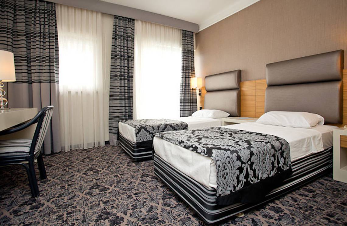 Zwei Betten mit schwarzen und weißen Mustern in einem Hotelzimmer des Cettia Beach Resort.