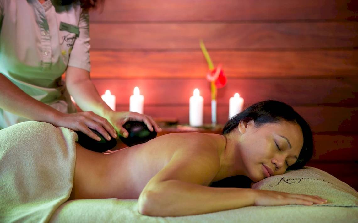Eine Frau genießt eine Massage im Kempinski Seychelles Resort.