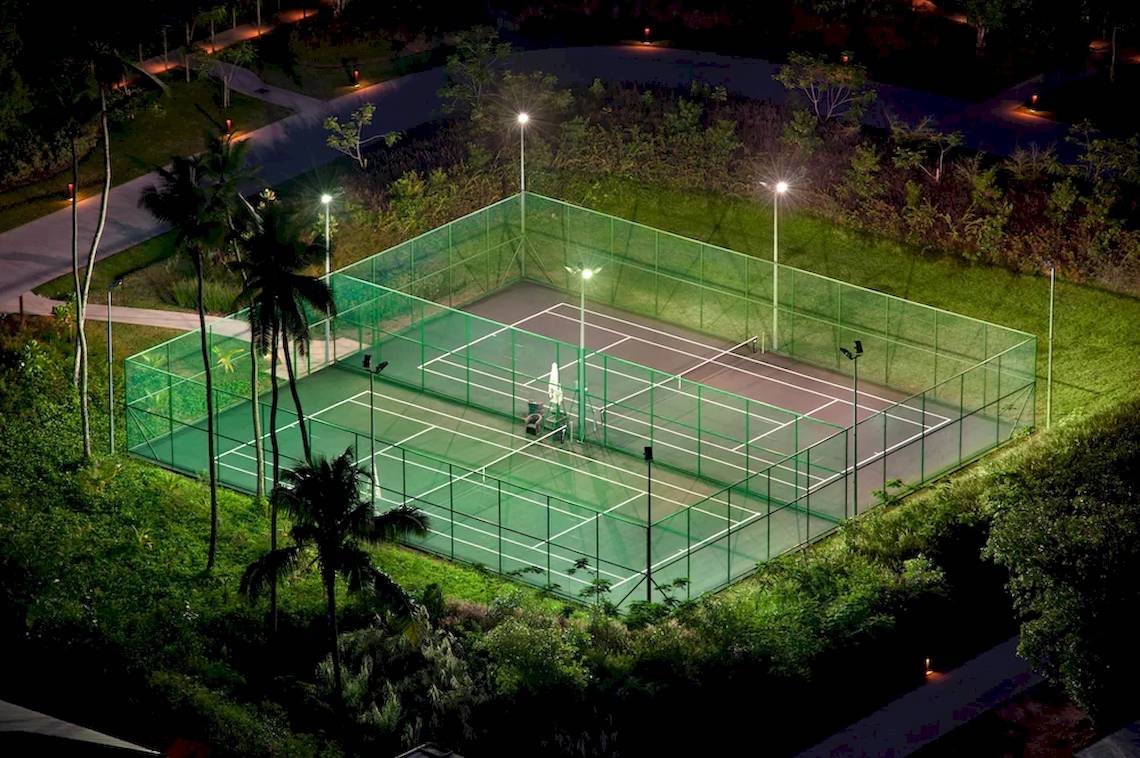 Tennisplatz bei Nacht im Kempinski Seychelles Resort, beleuchtet und umzäunt