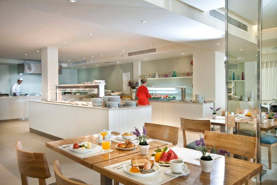 Frühstücksraum im Pernera Beach Hotel mit Buffet und Tischen, gedeckt für das Frühstück.