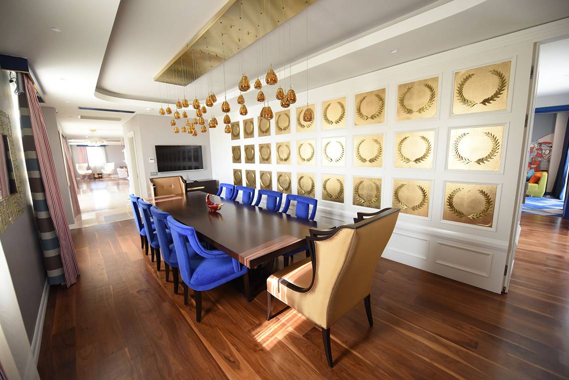 Das Speisezimmer im Land der Legenden Reich mit blauen Stühlen und goldenen Wandpaneelen.