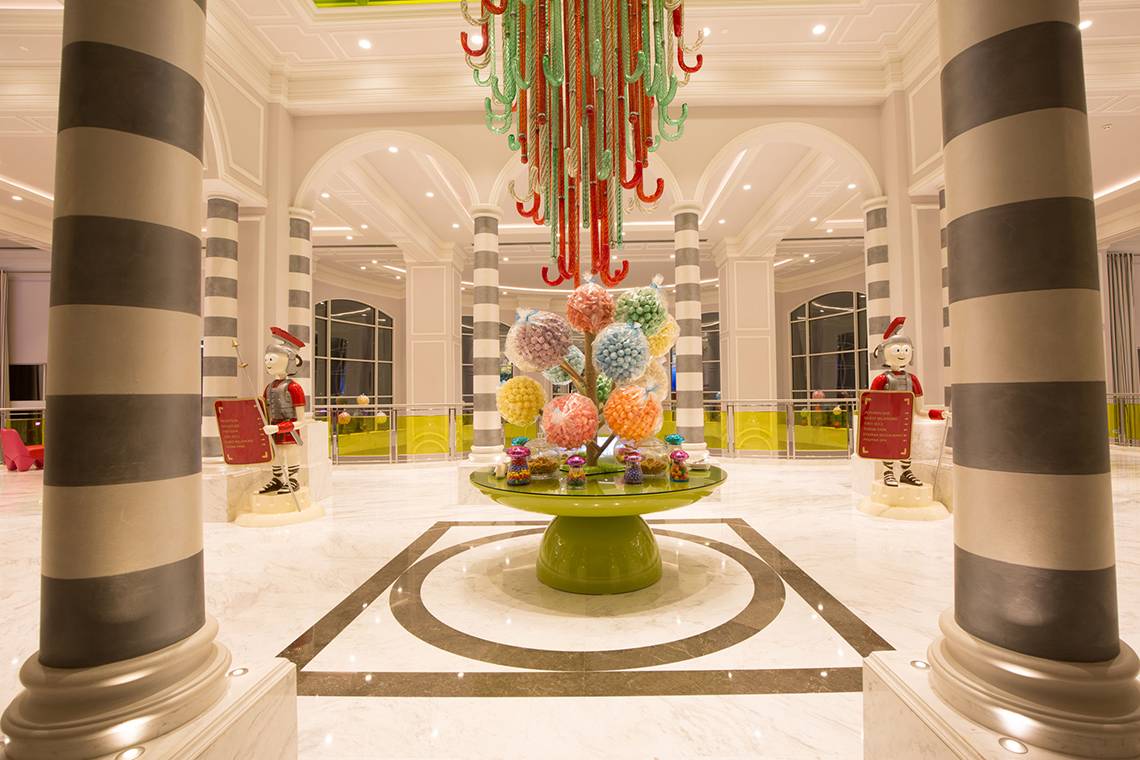 Empfangsbereich eines Hotels mit einem Lollipop-Baum und Säulen, The Land of Legends Kingdom