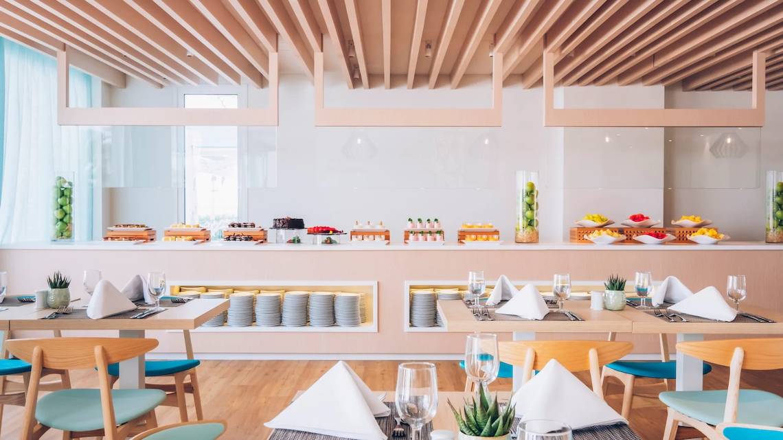 Innenansicht des Restaurants im Iberostar Waves Alcudia Park mit Buffet und gedeckten Tischen.