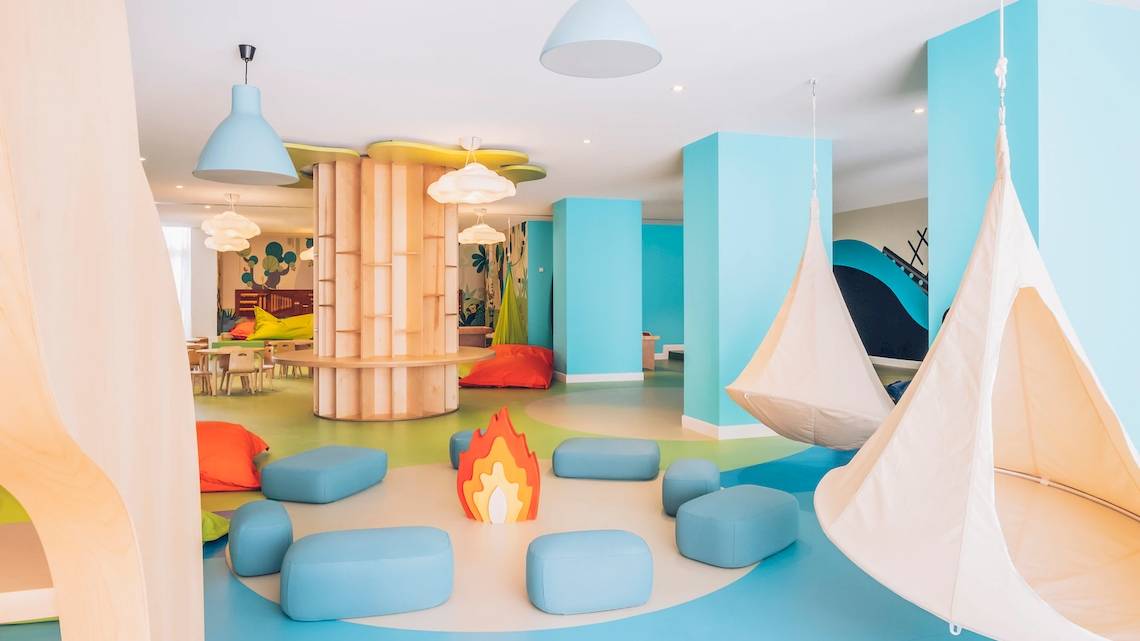 Kinderspielbereich im Iberostar Waves Alcudia Park Hotel mit bunten Möbeln und Hängesesseln.