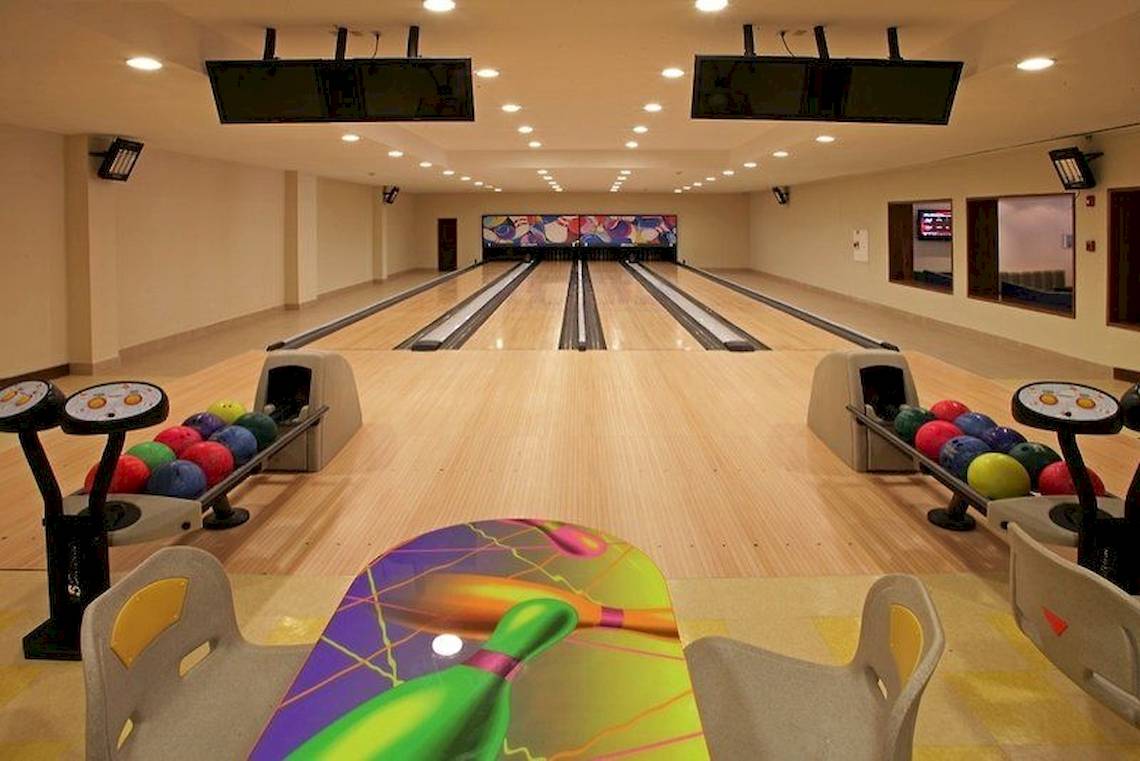 Bowlinghalle im Hotel Dreams Royal Beach Punta Cana mit Bowlingbahnen, Bowlingkugeln und Monitoren.