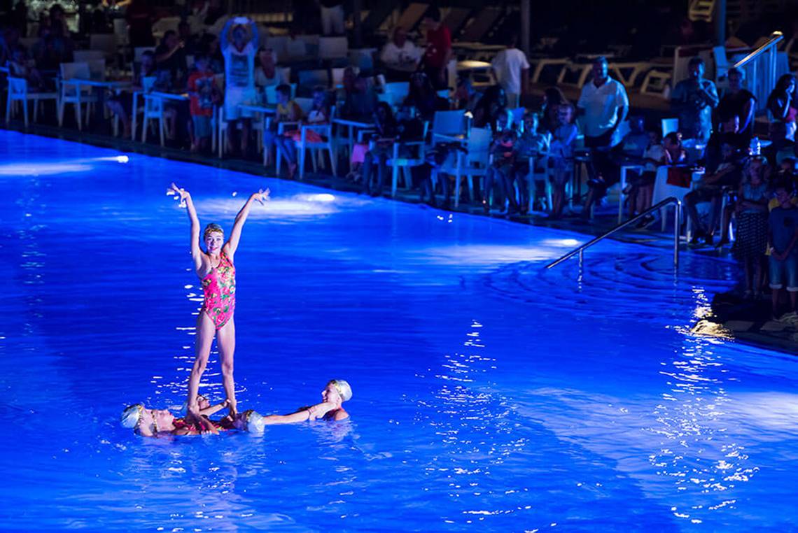 Schwimmbecken-Show bei Nacht im Club Nena mit Tänzerinnen im Wasser.