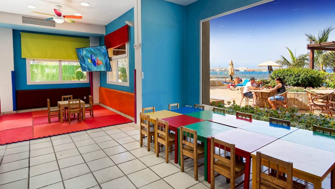 Kinderspielzimmer im Bull Dorado Beach & Spa Hotel mit bunten Möbeln und Fernseher.